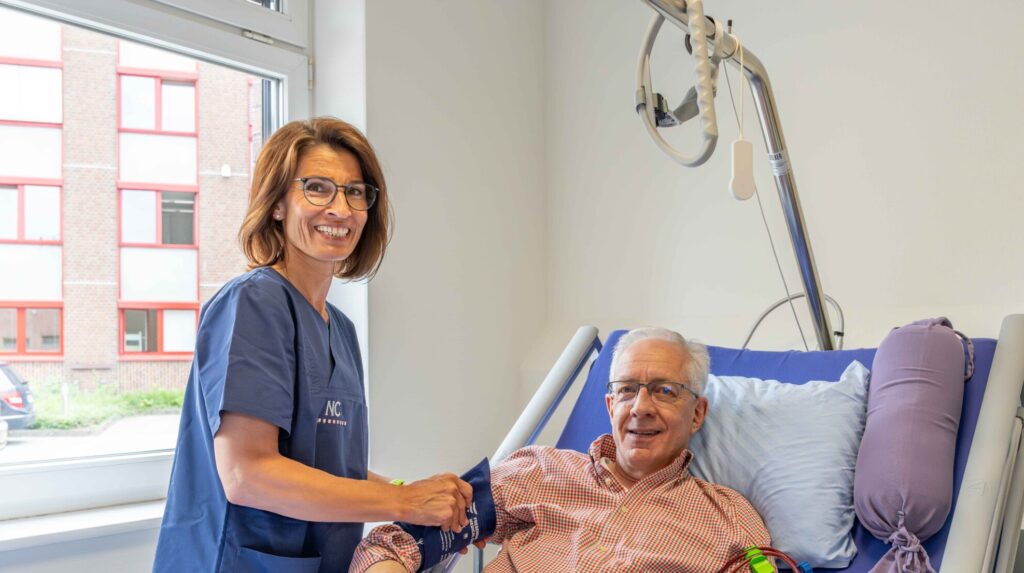 Eine Mitarbeiterin steht einem Patienten in der psychosoziale-begleitung zur Seite.